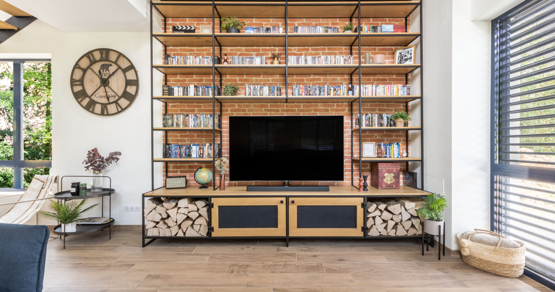 Meuble avec télévision et bibliothèque devant mur revêtit de plaquette de Brique ton rouge de chez ORSOL