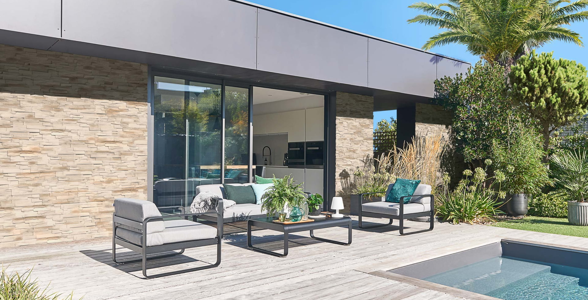 Maison d'architecte moderne ornée de parement GAIA avec terrasse en bois et piscine creusée