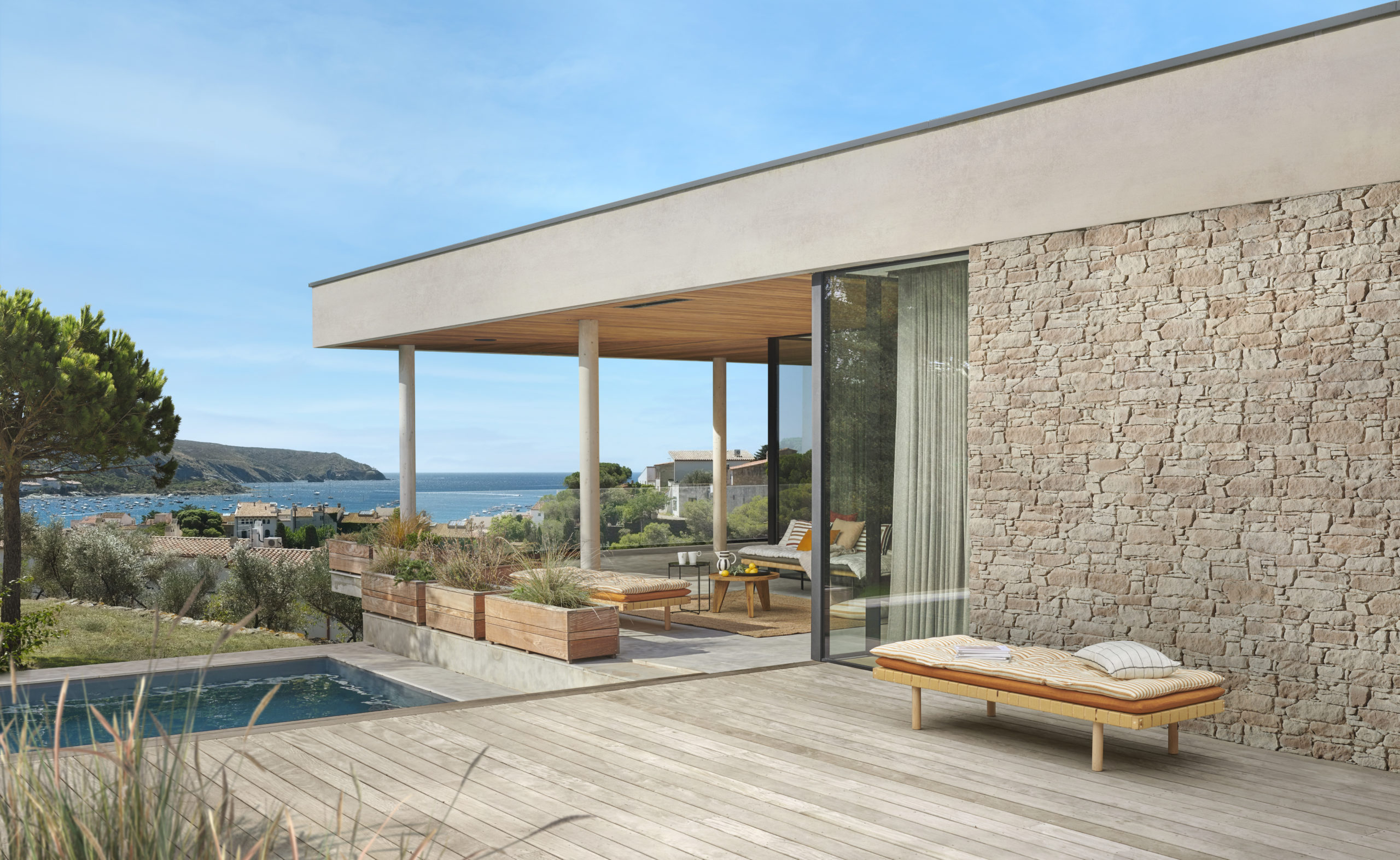 Façade de maison en parement Tertus à côté d'une terrasse en bois et d'une piscine creusée, à proximité d'une plage.