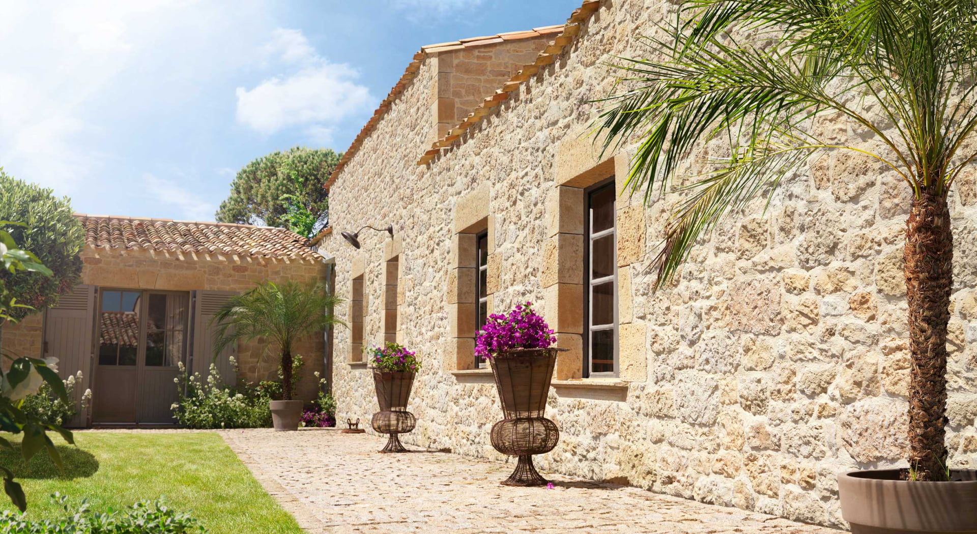 Cour d'une maison en brique avec recouvrement des murs en parement Manoir ton terre de sienne. Quatre fenêtres et une porte entourées d'angles et de linteaux de la gamme Manoir de chez ORSOL